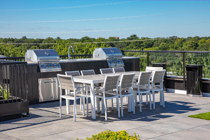 the wakpada minneapolis apartments rooftop with two grills for barbecuing and a large table for community seating